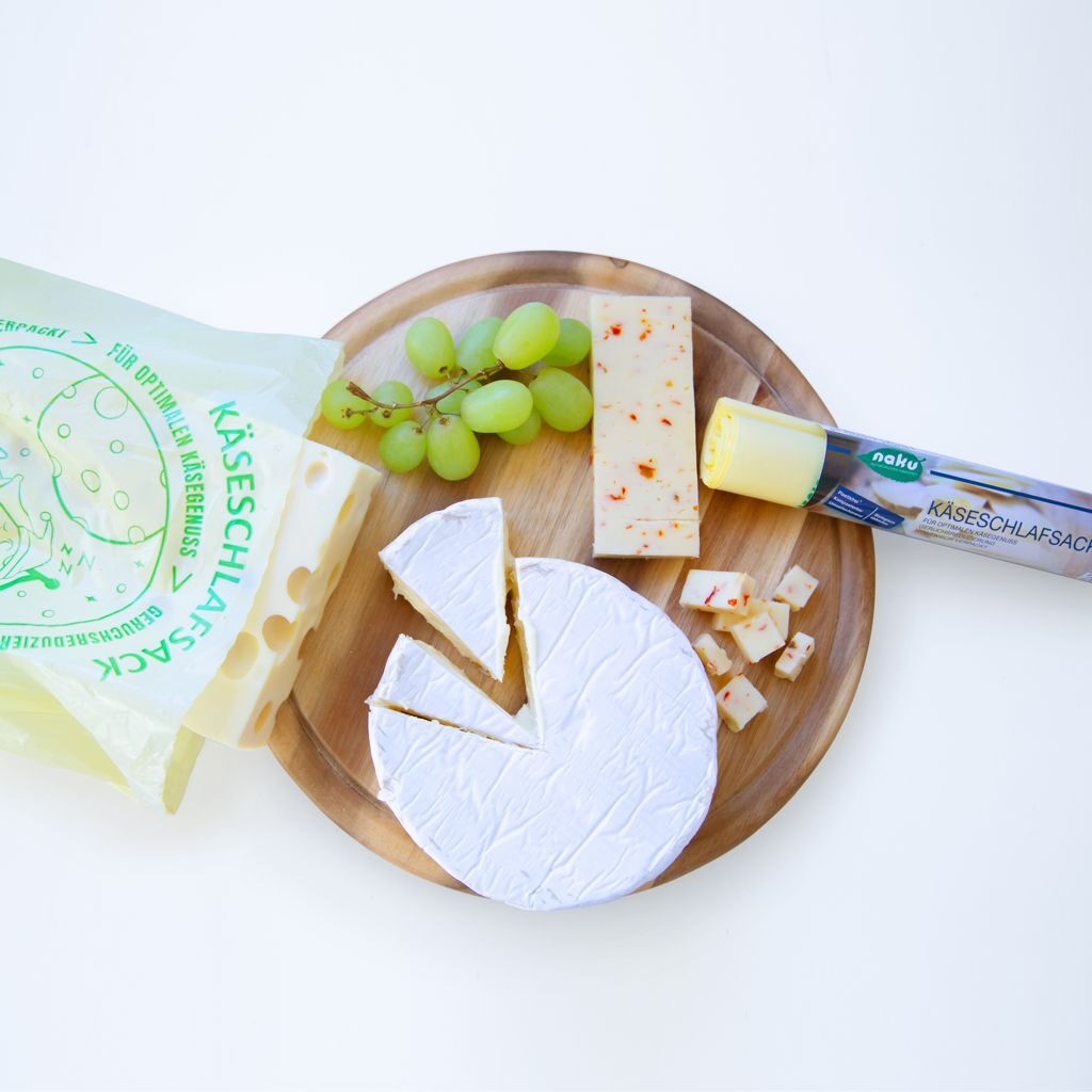 Cheese platter with the NaKu cheese sleeping bag made from bioplastics for optimal cheese storage and preservation of the cheese aroma.