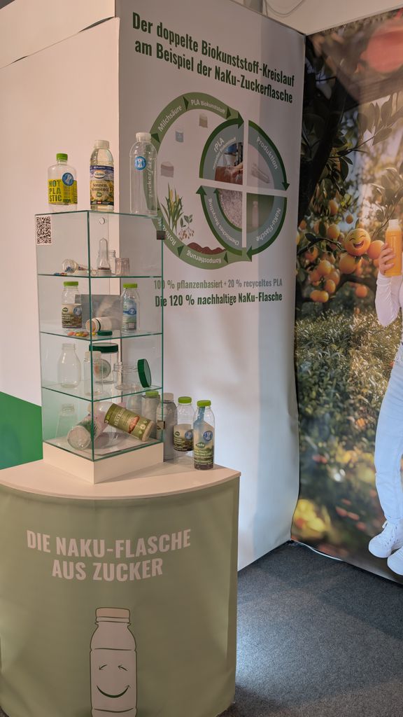 Fachpack 2025 - Die NaKu Bio-Flaschen-Ausstellung Ein Teil des NaKu Bioflaschen und Biodosen-Sortiments in der Vitrine