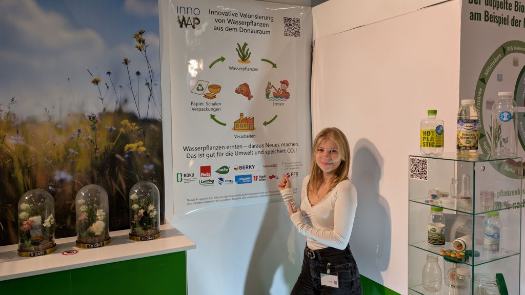 Lizzy auf der Fachpack vor dem InnoWAP Poster Vorstellung des InnoWAP Projekts auf der Fachpack 2025 am NaKu Messestand